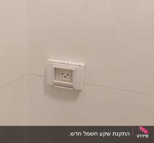 שקע חשמלי מותקן על קיר אריחים לבנים